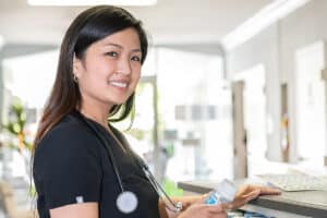 Smiling nurse at a nurses cart in the hallway