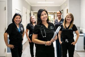 Several smiling nurses in the hallway