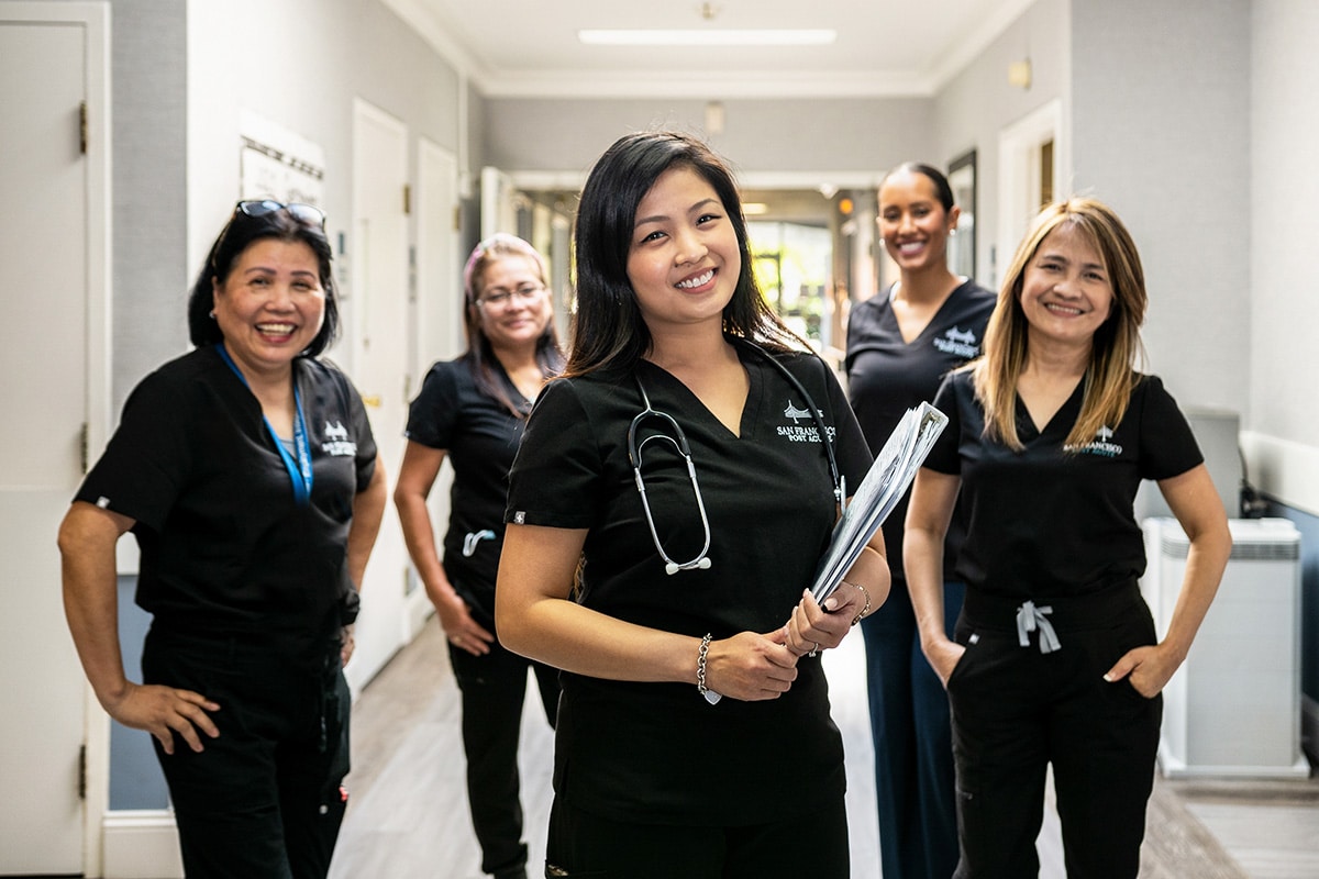 Several smiling nurses in the hallway