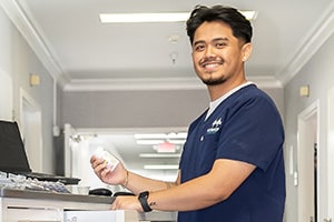 Smiling nurse at a nurses cart in the hallway